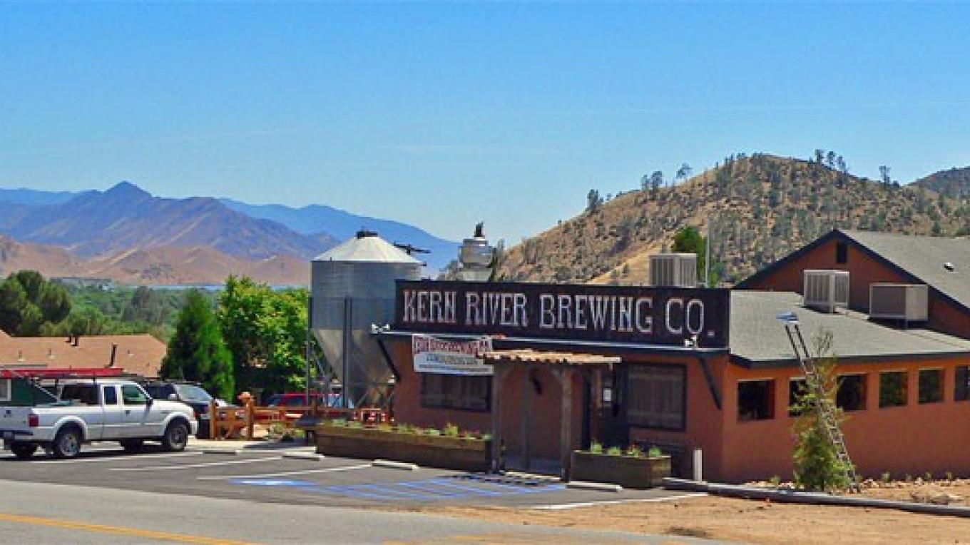 Just Outstanding IPA: A Hops Journey The exterior of Kern River Brewery with signs and open space - Just Outstanding IPA: The Journey of the Hops