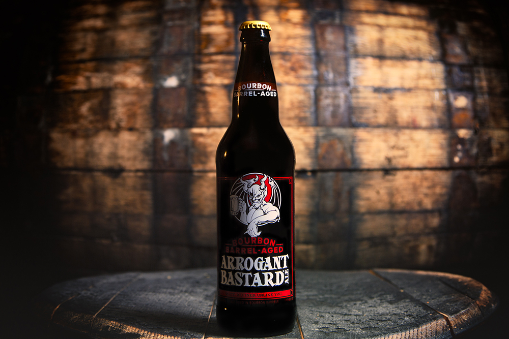 Cận cảnh chai OAKED Arrogant Bastard Ale với nhãn đặc trưng và ánh sáng ấm áp, gợi cảm giác cổ điển và cá tính Cận cảnh chai OAKED Arrogant Bastard Ale với nhãn đặc trưng và ánh sáng ấm áp, gợi cảm giác cổ điển và cá tính