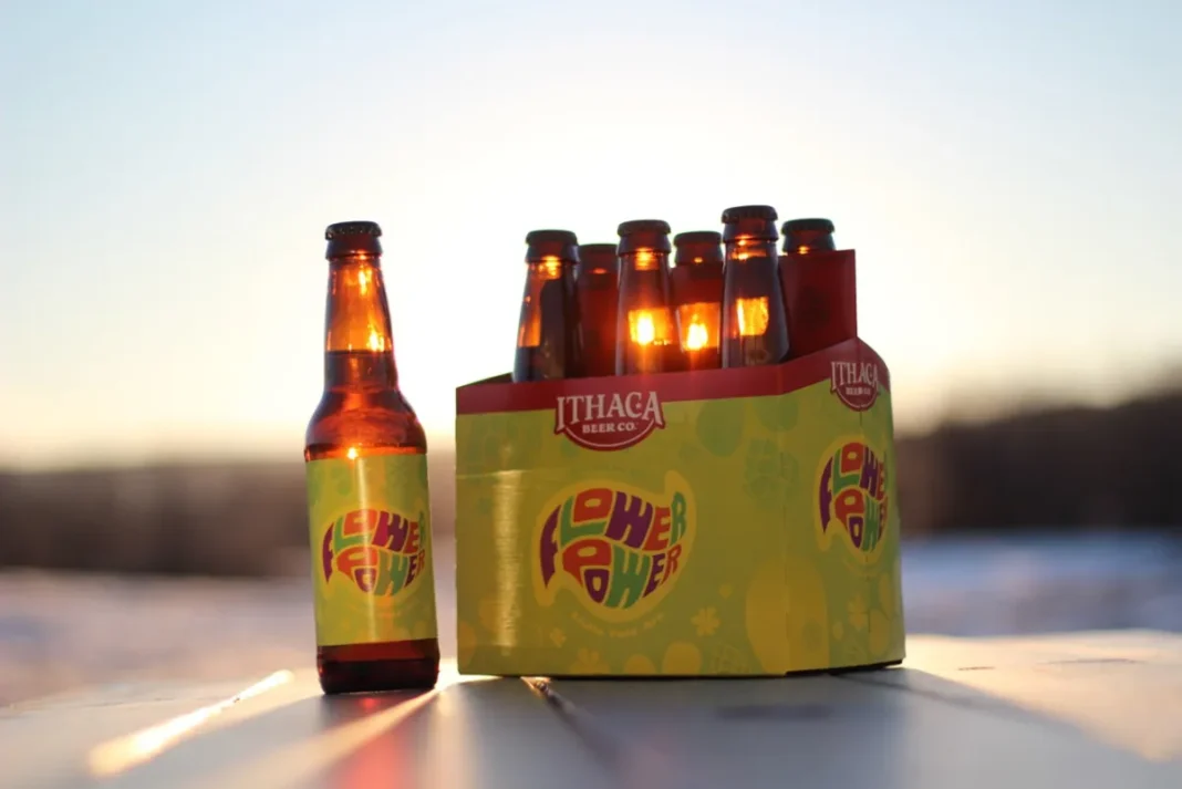 Chai Flower Power IPA nổi bật với nhãn hoa đặc trưng, đặt trên bàn gỗ mộc mạc.