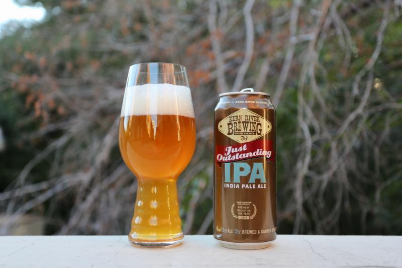 Just Outstanding IPA bottle on wooden table, natural light highlights the bottle label Just Outstanding IPA bottle on wooden table, natural light highlights the bottle label