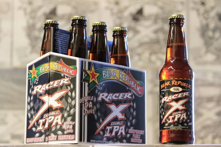 Chai Racer X Double IPA với nhãn đặc trưng, nổi bật trên nền gỗ tối Chai Racer X Double IPA với nhãn đặc trưng, nổi bật trên nền gỗ tối