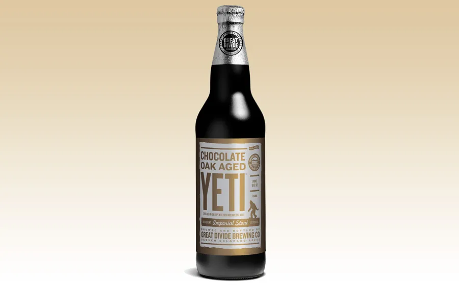 Chai bia Imperial Stout từ Great Divide với nhãn màu nâu, đặt trên bàn gỗ