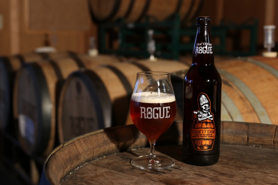 A clear, bright horizontal shot of a Dead 'N' Dead beer bottle showing off its distinctive amber color.