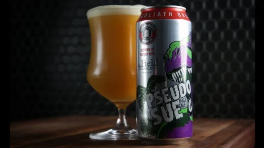 Pseudo Sue chai bia trên bàn gỗ