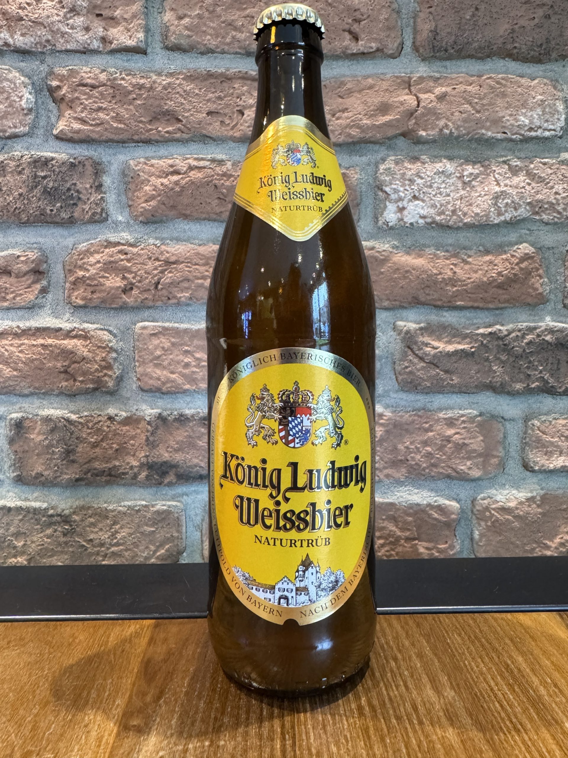 König Ludwig Weißbier hat ein markantes Golddesign mit geschuppten königlichen Motiven - König Ludwig Weißbier: Tauchen Sie ein in ein goldenes Erbe