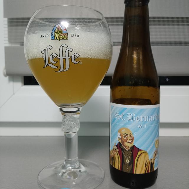 Image of a glass of St. Bernardus Wit beer with a glass of red wine - Wit: Immerse Yourself in the Cloudy Yellow Color from the Heart of Belgium