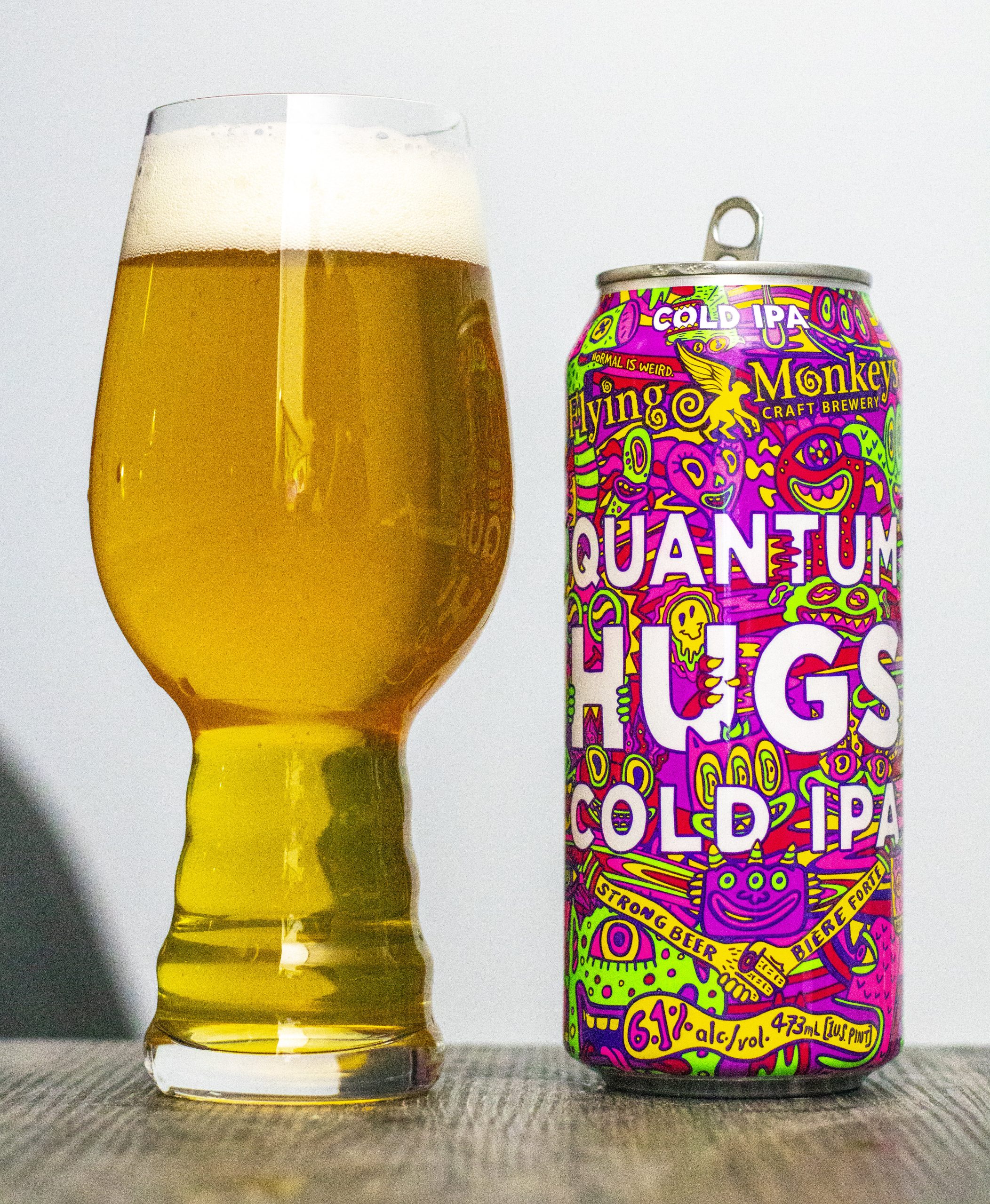 The beer has a translucent golden-yellow color so clear you can see through the scaled-down version - Quantum Hugs Cold IPA: Where Excellence is Encapsulated