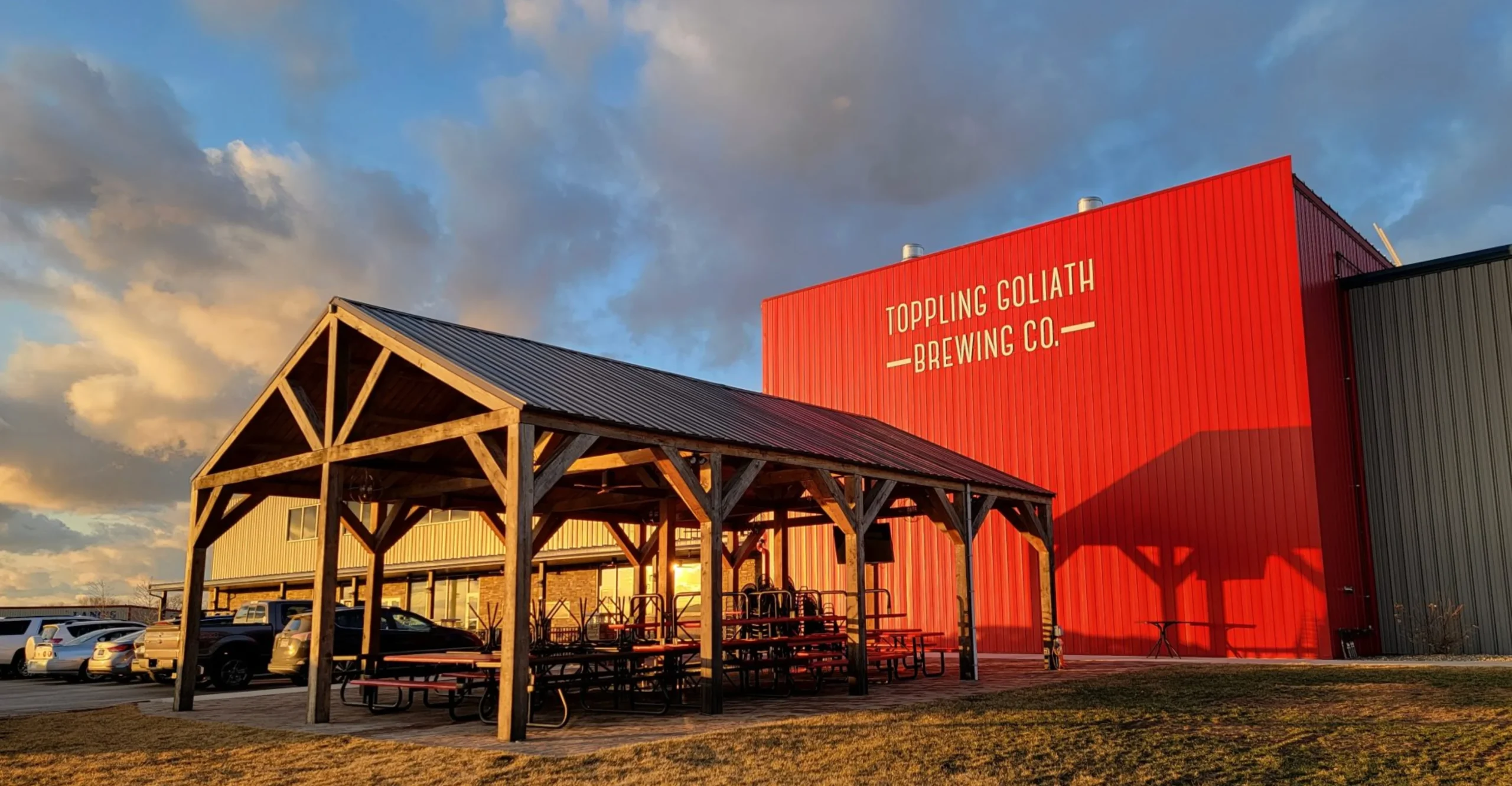 An exterior photo of the Toppling Goliath Brewing Company brewery under a scaled-down sunset light - Pseudo Sue - Double Dry Hop: Citra Hop Dream
