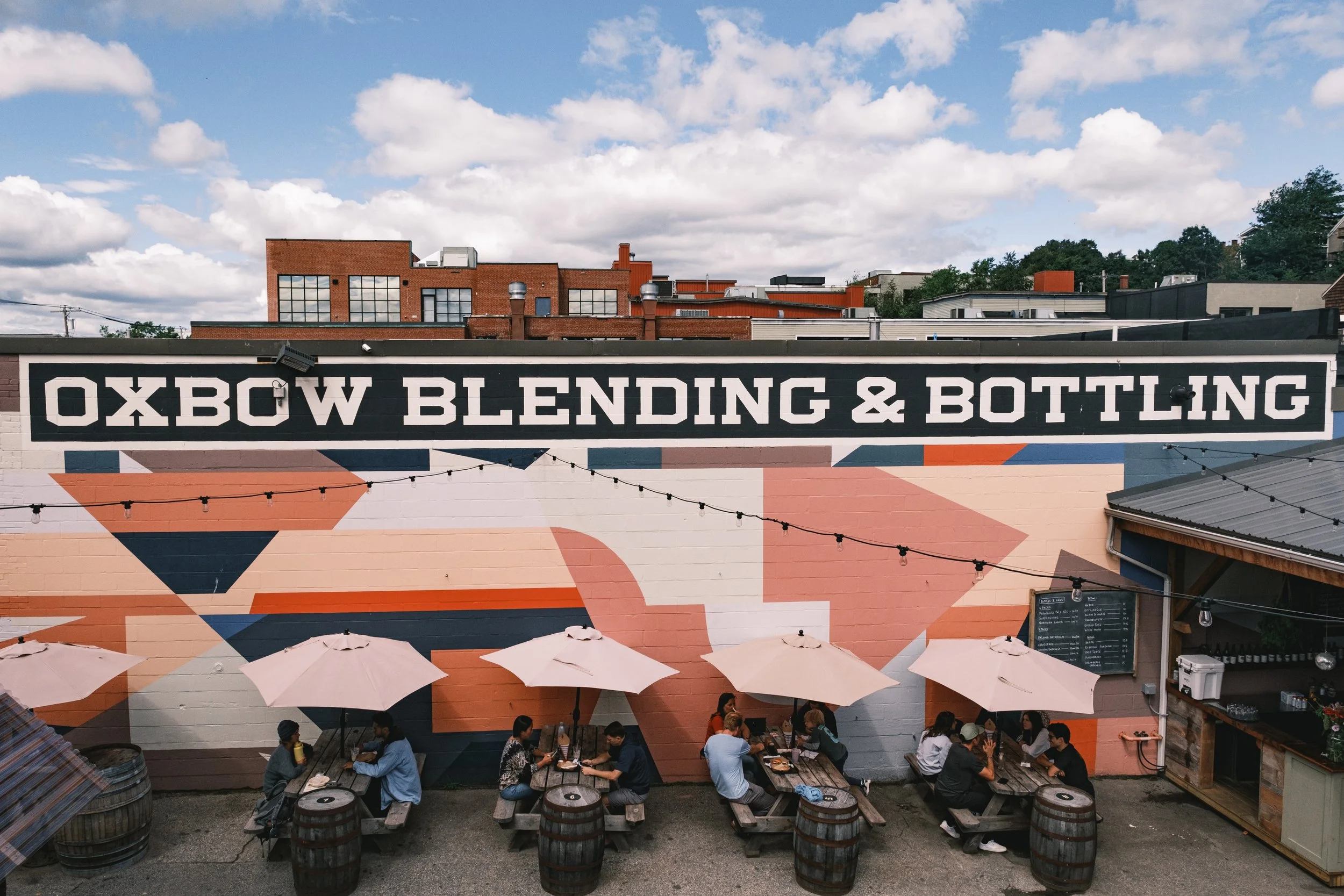The image shows a striking wall with vibrant colors outside the Oxbow Brewing Company - Luppolo brewery: A Sunny Prelude in a Glass.