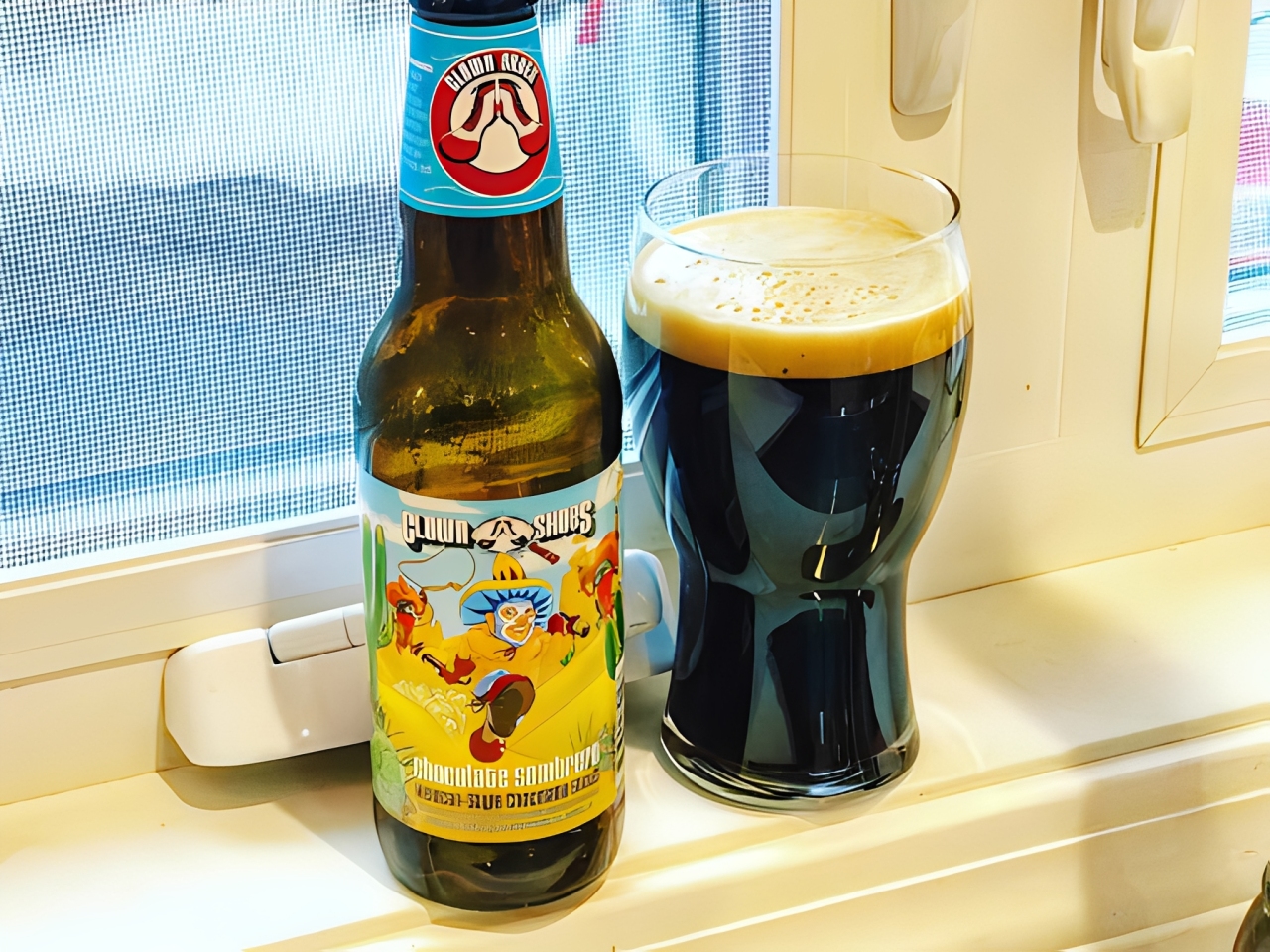 ドア番号1の隣にあるチョコレートソンブレロのボトルと黒ビールのグラスの画像 - チョコレートソンブレロ：暗闇の中の温かい味