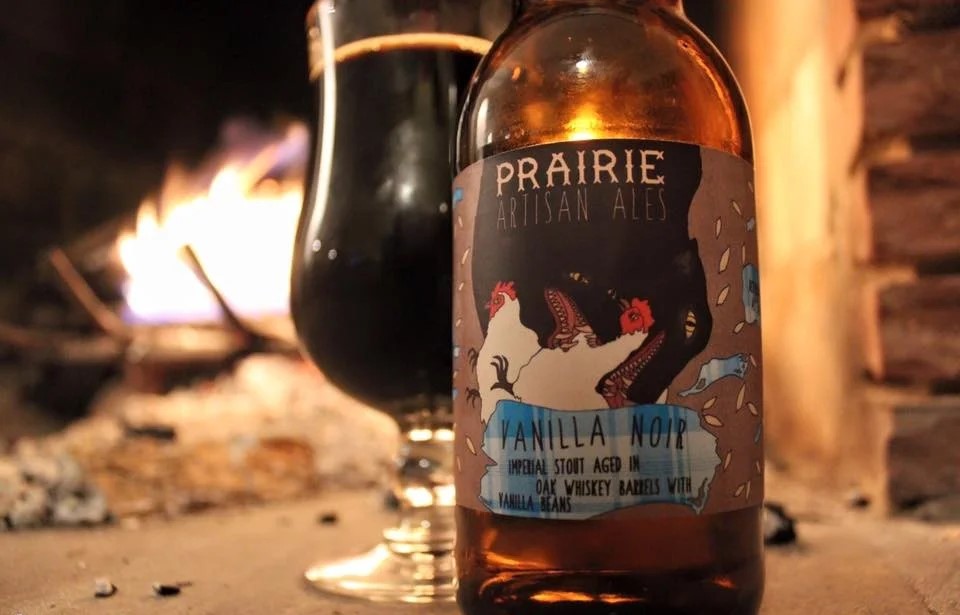 燃え盛る炎の横に置かれたバニラ・ノワールのグラスの画像 1 - バニラ・ノワール：甘さを再定義する記念碑